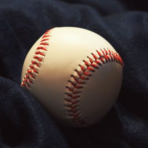 A baseball on top of a black sheet.