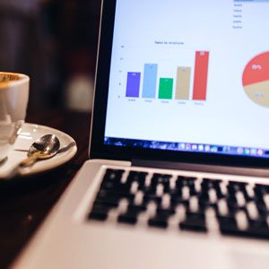 A laptop at a coffee shop looking at business profit data.