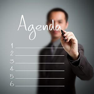 A business is writing the agenda for the day to make his day more productive.